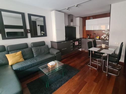 a living room with a couch and a table and a kitchen at Warta LUX Apartment, self check-in 24h, free parking in Poznań