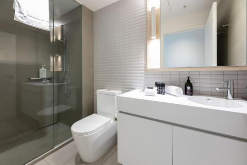 La salle de bains est pourvue de toilettes, d'un lavabo et d'une douche. dans l'établissement Sanctuary-Effortless City Escape, à Melbourne
