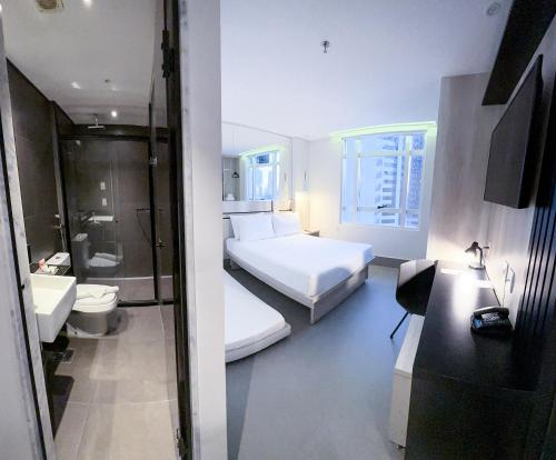 a hotel room with two beds and a bathroom at Hotel Black Inn Flamboyant in Goiânia