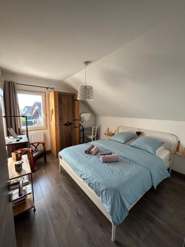 a bedroom with a large bed with blue sheets at Le Cosy Home Annecy in La Balme-de-Sillingy