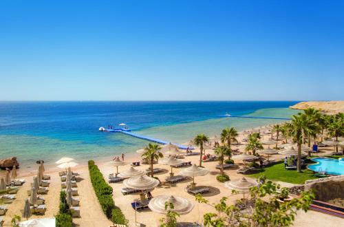 a view of a beach with palm trees and the ocean at Royal Savoy Sharm El Sheikh in Sharm El Sheikh