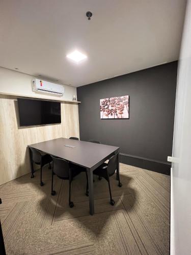 a conference room with a table and chairs in it at Hotel Black Inn Flamboyant in Goiânia