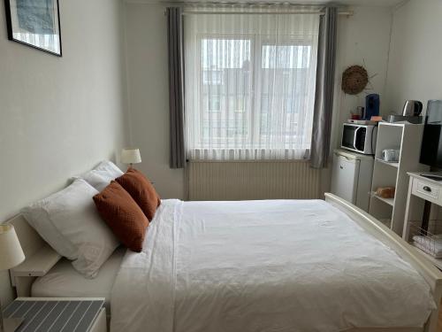 a bedroom with a white bed and a window at Room in Oss in Oss
