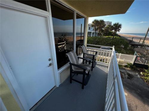 a balcony with two chairs and a view of the beach at Sapphire Shores- Oceanfront at Symphony Beach Club in Ormond Beach