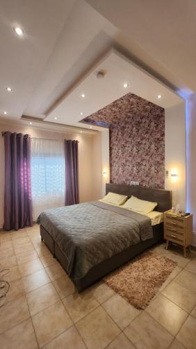 a large bedroom with a large bed and a brick wall at Résidence Deluxe in Yaoundé