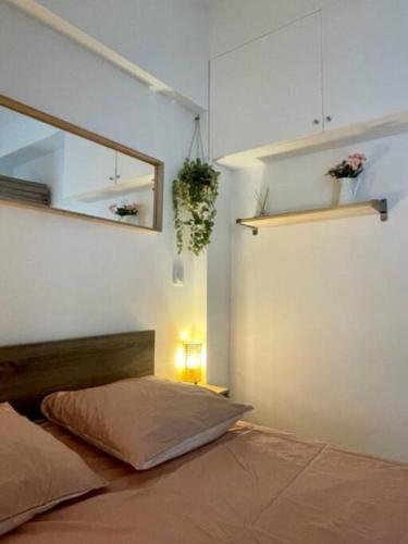 une chambre avec un lit et un miroir au mur dans l'établissement La Maisonnette, à Nice