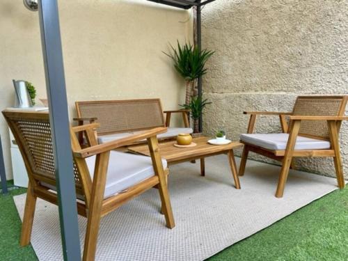 d'une terrasse avec 2 chaises, une table et un banc en bois. dans l'établissement La Maisonnette, à Nice
