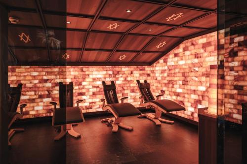 a waiting room with three chairs and a brick wall at ARPURIA l 4 Star Superior l Adults Only in Sankt Anton am Arlberg