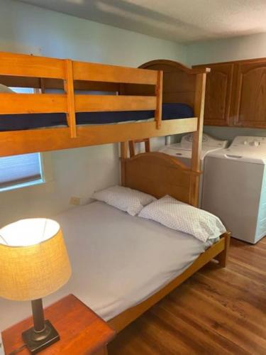 a bedroom with two bunk beds with a lamp and a table at Blueberry Cottage Lake Champlain in Plattsburgh