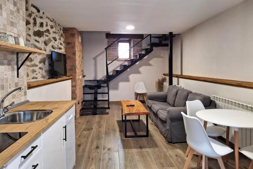 eine Küche und ein Wohnzimmer mit einem Sofa und einem Tisch in der Unterkunft El Hilo de los Sueños in Navatalgordo