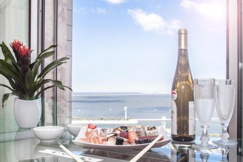 a table with a plate of food and a bottle of wine at Oriente 25 Apartments by APT IIN - Parque das Nações in Lisbon