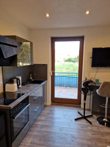 une cuisine avec un évier et une cuisinière four supérieur dans l'établissement Ferienwohnung Schwarzwald friedhofstraße 13, à Obersasbach