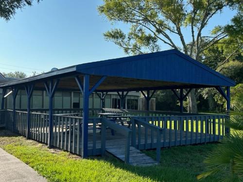 un pabellón azul con mesas de picnic en un parque en Days Inn by Wyndham Crystal River, en Crystal River