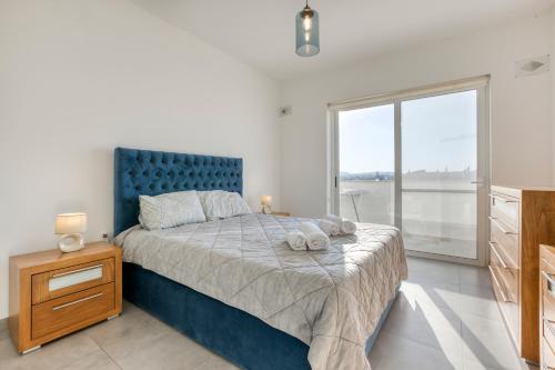 um quarto com uma cama grande e uma cabeceira azul em Annitchka Mansions - Penthouse in central Malta em Birkirkara