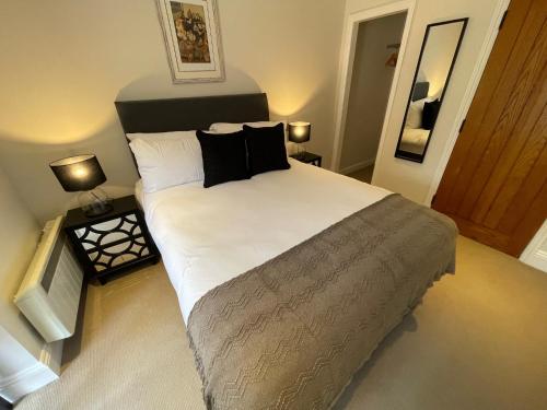 1 dormitorio con 1 cama grande con almohadas negras en The Crown of Cookham, en Cookham