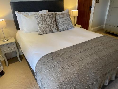 a bedroom with a large bed with pillows at The Crown of Cookham in Cookham