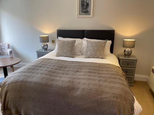 1 dormitorio con 1 cama grande, 2 mesas y 2 lámparas en The Crown of Cookham en Cookham