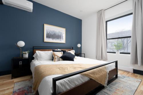 una camera da letto con pareti blu e un letto con cuscini di Les Suites Saint-Laurent a Montréal