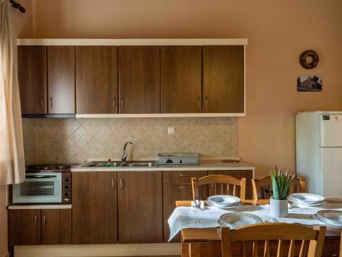 a kitchen with wooden cabinets and a table with chairs at Karyon Apartments in Kariófiton