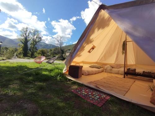 a tent with a bed and a tv in a field at CAMPING LA ZARAPICA - Palacios del Sil in Palacios del Sil