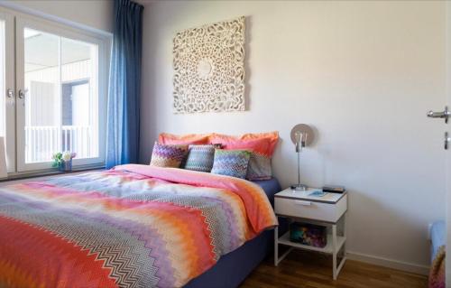 a bedroom with a colorful bed and a window at Fresh and cosy apartment in the center of the city in Stockholm