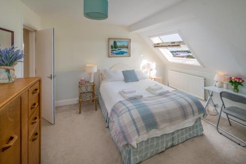 a bedroom with a bed and a desk and a window at 3 BR Central Cowes, Sleeps 8, Sea Views, free parking, ferry voucher LONG TERM DEALS AVAILABLE in Cowes