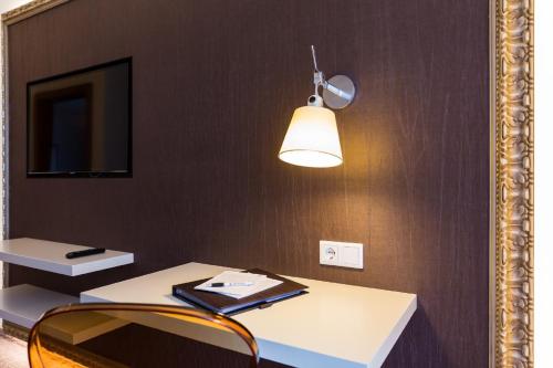 a mirror reflection of a table and a light at GORITSCHNIGGs Hotel - Self Check-In in Velden am Wörthersee