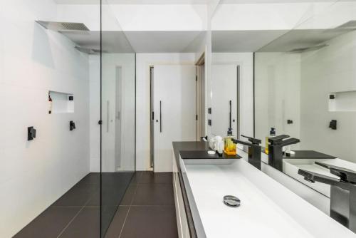 uma casa de banho com um lavatório e um espelho em Elegant Port Melbourne Home Mins to Cafes and Beach by Custom Bnb Hosting em Melbourne