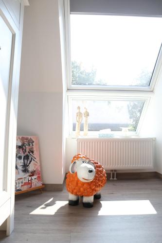 a stuffed cow toy in a room with a window at Galerie23noordsleen in Noord-Sleen