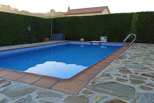 ein großer Pool in einem Hof mit Hecke in der Unterkunft CASA AREALBA Casa con piscina muy cerca de las playas de San Xurxo y Doniños in Ferrol