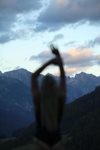 a person with their hands in the air looking at the mountains at ARPURIA l 4 Star Superior l Adults Only in Sankt Anton am Arlberg
