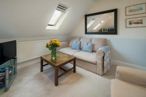 a living room with a couch and a table with flowers at 3 BR Central Cowes, Sleeps 8, Sea Views, free parking, ferry voucher LONG TERM DEALS AVAILABLE in Cowes