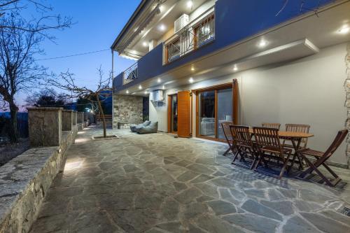 a patio with chairs and a table in front of a house at orminia house upper level in Monolíthion