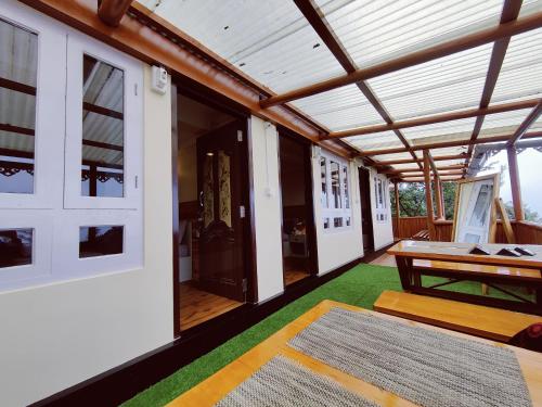 ein Wohnzimmer mit einem Tisch und einem grünen Teppich in der Unterkunft Mandala Fram Stay in Darjeeling