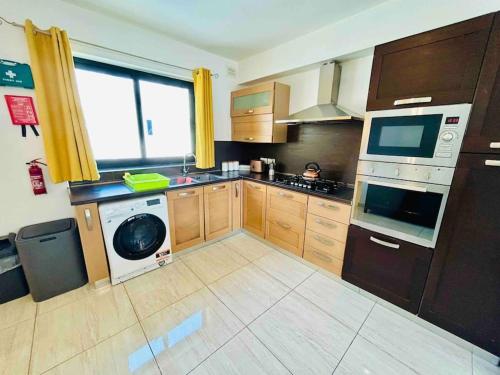 a kitchen with a washer and a dishwasher at Duplex Whiskey Home 200m away from the Sea and the Square in St. Paul's Bay