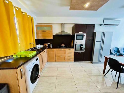 a kitchen with a washer and a stove top oven at Duplex Whiskey Home 200m away from the Sea and the Square in St. Paul's Bay