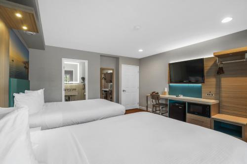 a hotel room with two beds and a flat screen tv at Motel Mediteran in Escondido