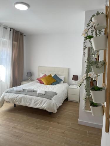 a bedroom with a white bed and a wooden floor at Resitur Luxury Suit 514 in Seville