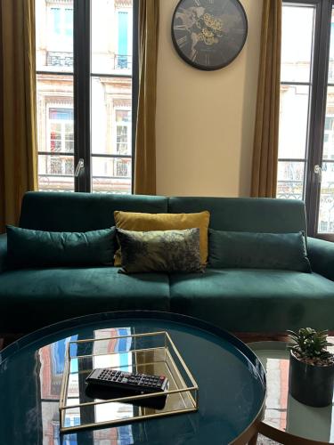 a living room with a green couch and a glass table at Appart.confortable, place Dupuy. in Toulouse