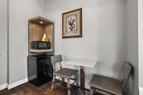 a room with a table and a chair and a microwave at Motel Mediteran in Escondido