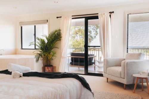 een slaapkamer met een bed, een stoel en een raam bij Cheerful family home with stunning views in Caloundra