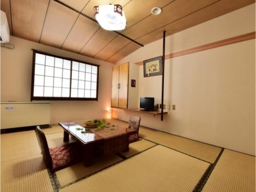 a room with a table and chairs and a window at Ｇｕｅｓｔ Ｈｏｕｓｅ Ｔａｋｅｎｏｙａ - Vacation STAY 76198v in Omachi