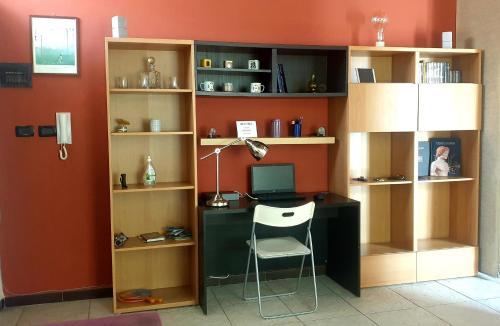 Habitación con escritorio, ordenador y estanterías. en La Casita, en Reggio Calabria