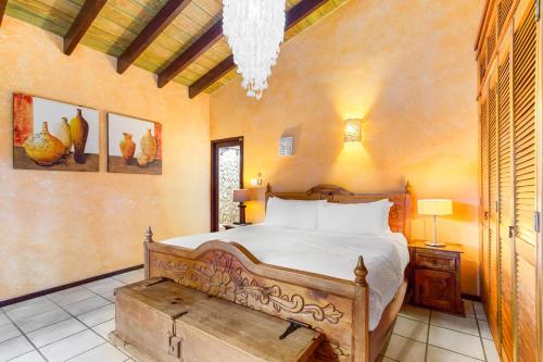 a bedroom with a large bed with a wooden bed frame at Villa Aloe in Paradijs