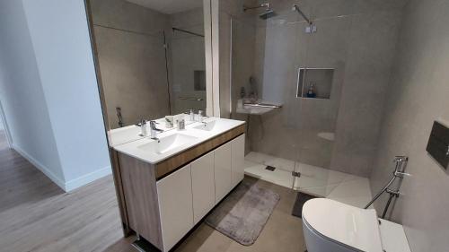 a bathroom with a white sink and a shower at Sol do Til Apartment in Funchal