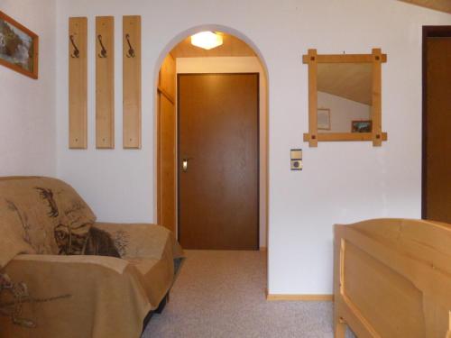 a room with a door and a chair and a mirror at Ferienhaus Tirolerhof in Kals am Großglockner