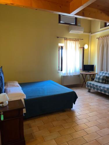 a bedroom with a blue bed and a couch at Taverna dei Guelfi in Senigallia