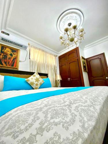 1 dormitorio con 1 cama grande y lámpara de araña en Habitación a cinco minutos del aeropuerto y terminal terrestre, en Guayaquil