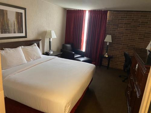 a hotel room with a large bed and a chair at Hotel Lotus Kansas City Merriam in Merriam