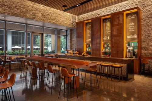 a bar in a restaurant with a long table and stools at EAST Miami in Miami